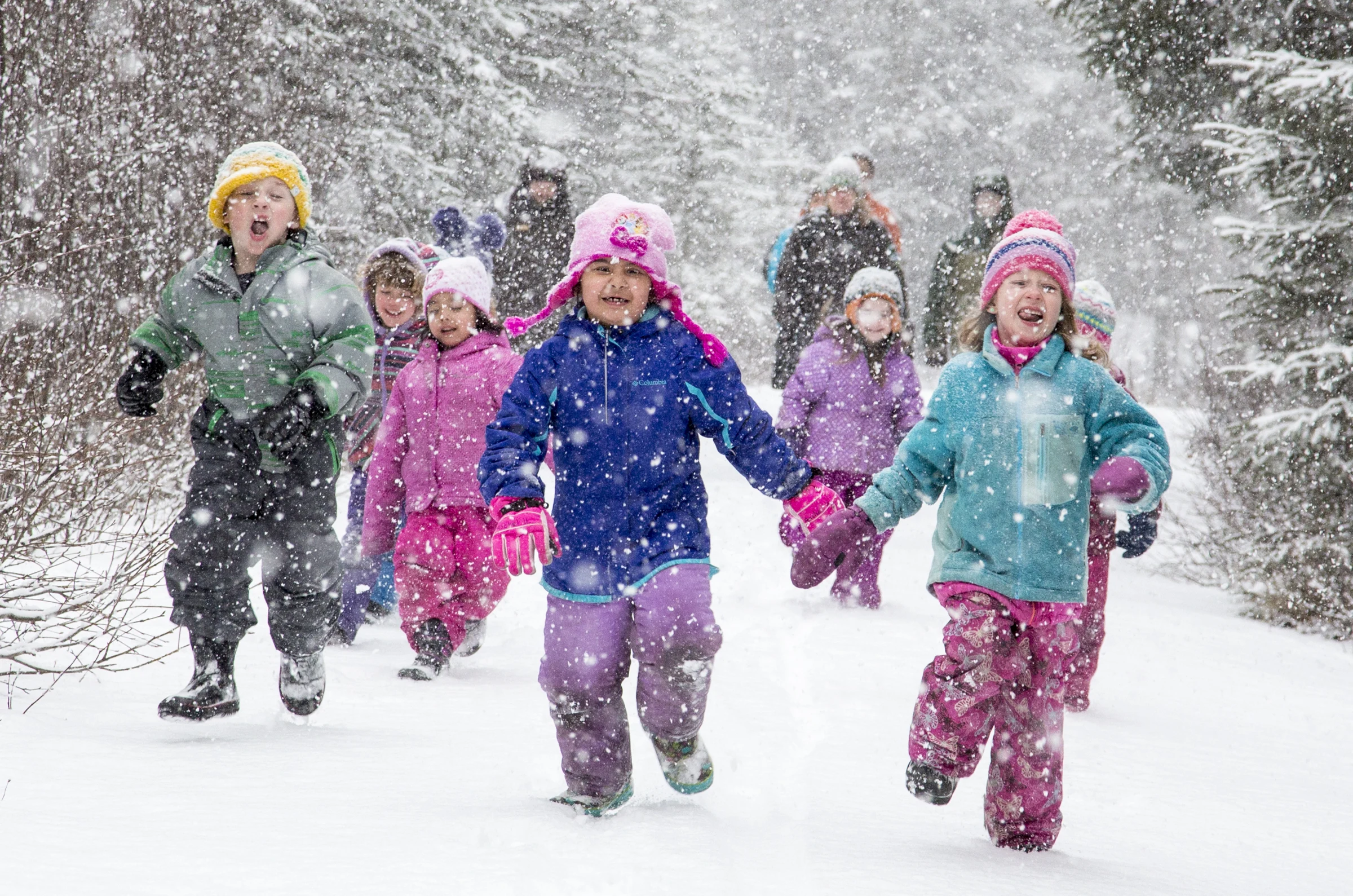 Children running through falling snow on the Iditarod National Historic Trail