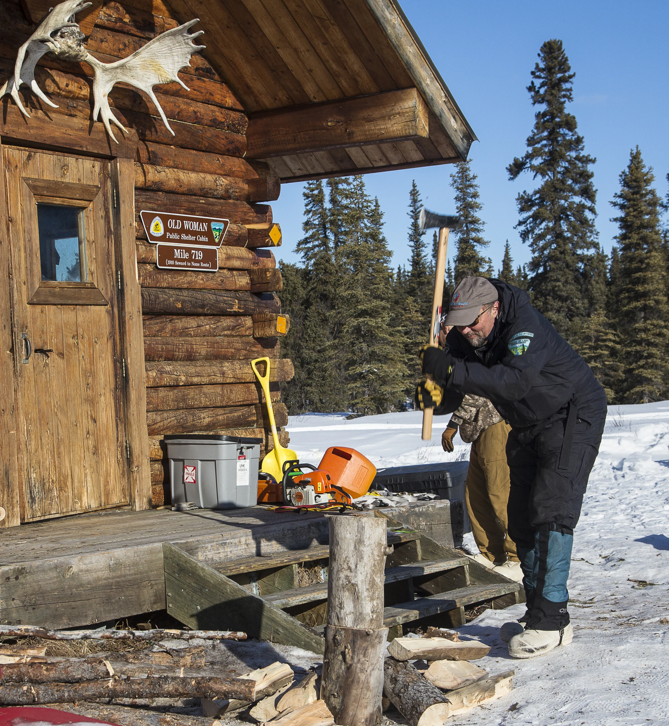 BLM trail administrator Kevin Keeler splitting wood outside Old Woman Cabin